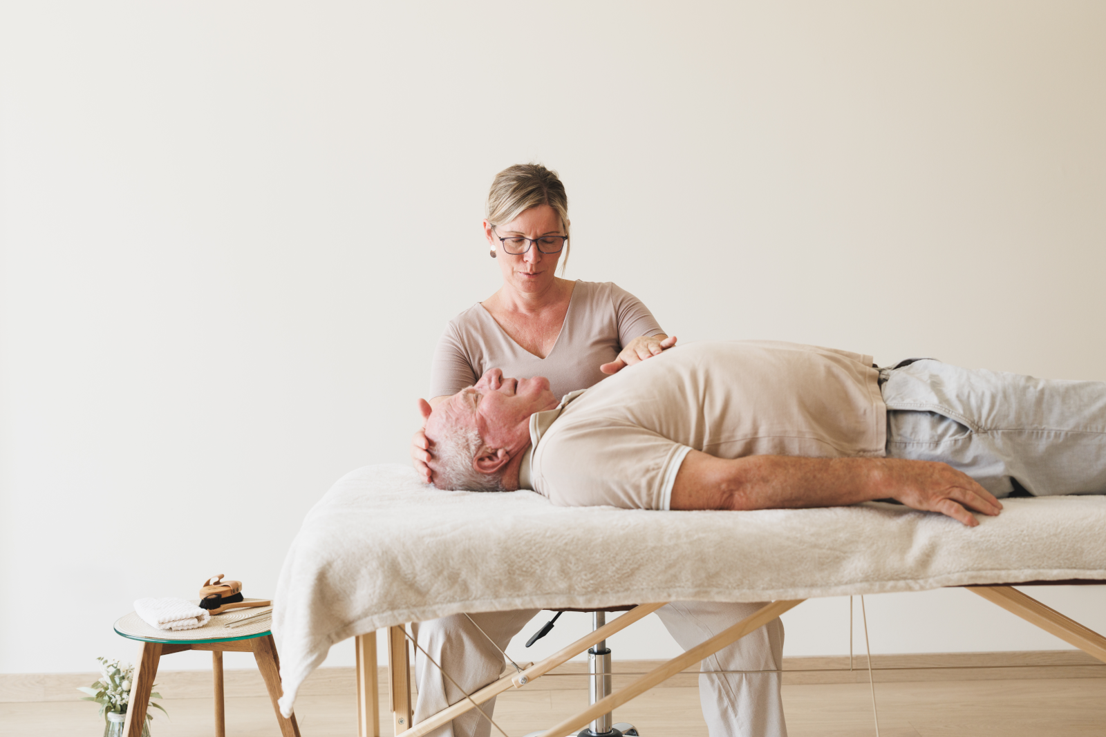 Eveline Grasmuck beim Heilströmen an einem älteren Herrn, der auf einer Liege liegt