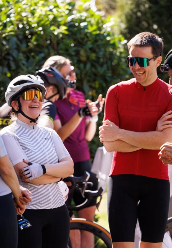 Gruppe Rennradfahrer steht lachend zusammen