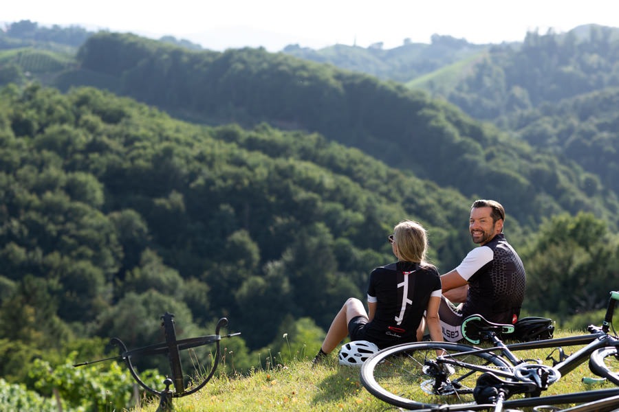 Rennradfahrer machen Pause und sitzen im Gras