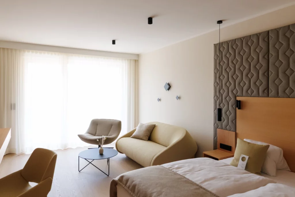 Gemütliches Zimmer mit Sofa, Bett und kleinem Tisch im Weinlandhof Gamlitz